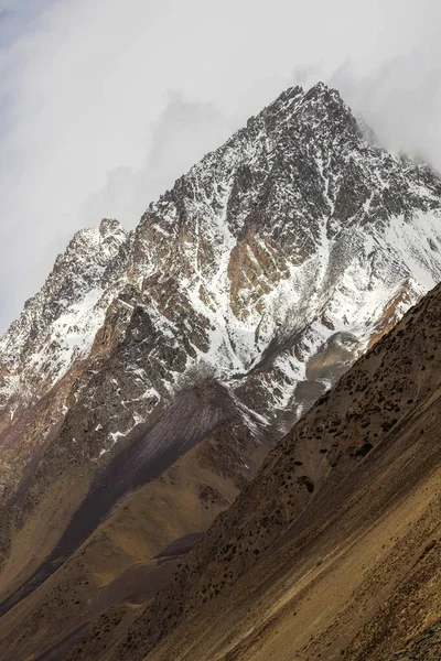 Kırgızistan 'ın karla kaplı dağları sakin bir açık hava ortamında görkemli bir şekilde yükselir. Rocky tepeleri açık mavi gökyüzüne karşı çarpıcı bir zıtlık yaratır, sükunet ve soğukluk hissi uyandırır..