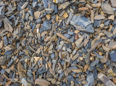 Değişik boyutlarda ve kahverengi ve gri tonlarda kayalar yere saçılmış. Sert dokular doğal bir doğa ortamında dünyevi bir hava yaratır..