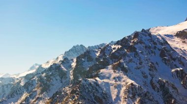 Gökyüzü açık mavi gökyüzü altında Kırgızistan 'da nefes kesen karlı dağları yakalıyor. Sağ kamera hareketine yay.