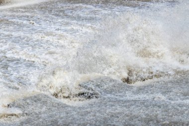 Parlak gün ışığı altında güçlü bir nehirde su sıçrar ve çalkalanır. Sahne doğanın ham enerjisini yakalar ve akan suyun gücünü gösterir..