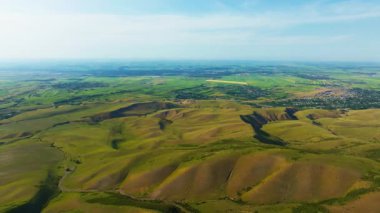 Kırgızistan kırsalının tepeli ve köylü havadan görüntüsü, ileri doğru hareketli kamera hareketi.