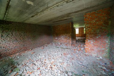 Terk edilmiş bina vitrinlerinin yıkılmış tuğla duvarlar ve dağınık döküntüler. Gün ışığı, uzayın tüyler ürpertici ve harap atmosferini arttırır..