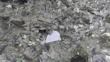 Kırık cam parçaları açık hava enkazına saçılmış. Keskin kenarlar ve yansıtıcı yüzeyler kaotik ve tehlikeli bir sahne yaratır..