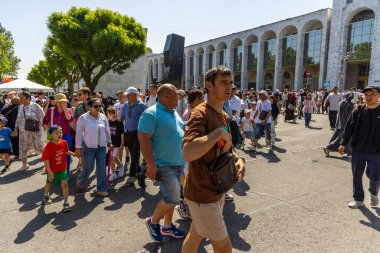 Kırgızistan 'ın Bişkek kentindeki zafer töreninden sonra güneşli bir şehir caddesinde gelişigüzel yürüyen bir grup insan 8 Mayıs 2025