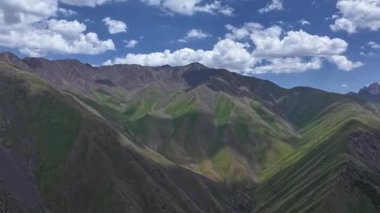 Uzak yabanda görkemli dağlar yükselir. Parlak güneş ışığı ve hava hiper kayması ile aydınlanır. Yumuşak bulutlar yukarı doğru sürükleniyor, sakin bir gündüz manzarası yaratıyor..