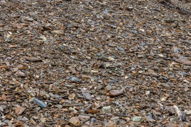 Pek çok renkli taşla kaplı engebeli kayalık arazi ıssız bir atmosfer yaratır. Gün ışığı kaya boyutları ve renklerindeki dokuları ve varyasyonları vurgular.