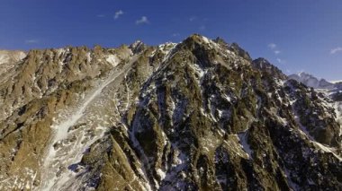 Görkemli dağ sıraları, temiz gökyüzünün altındaki engebeli tepelerde kar parçaları sergiliyor. Uçsuz bucaksız manzara, doğada huzur ve huşu uyandırır. Bitmiş görünüm.