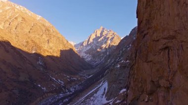 Uçsuz bucaksız dağ manzarasında karlı tepeler ve kayalık arazi bulunur. Sakin bir atmosfer gündüz vakti huzurlu bir açık hava manzarası yaratır..