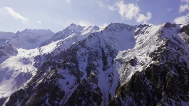 Güneşli kış gününde, tortulu dağ sırtı karla kaplıydı. Kamyon sol kamera hareketine.