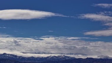 Akşamları karla kaplı engin dağların üzerinden akan bulutlar..