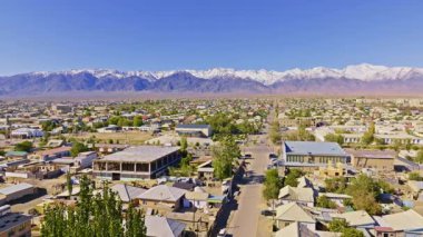 Kırgızistan 'daki görkemli dağlarla çevrili Balykchy şehri havadan görülebiliyor. Açık gökyüzü, gündüz güneşinin dingin atmosferini arttırır.