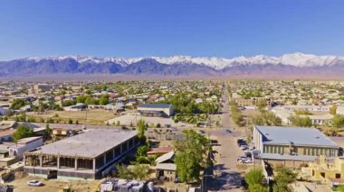İnsansız hava aracı görüntüsü, Balykchy 'nin karlı dağlarla kaplı vadideki yuvasını yakalıyor. Dolly ileri kamera hareketi.