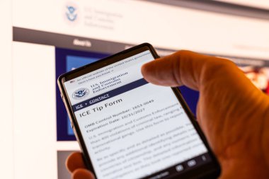 ABD Göçmen Bürosu 'nun internet sitesinde 13 Şubat 2026' da Balykchy, Kırgızistan 'da ihbar formu bulunan bir telefonla el ele tutuşmak.