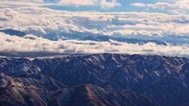 Kırgızistan 'da hava manzarası dramatik bulutlar altında geniş sıradağları yakalar. Gün ışığı, doğal manzaranın dingin güzelliğini arttırır..