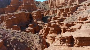 Kırgızistan kanyonundaki kurak uçurumların görkemli jeolojik oluşumlarını görüntüler. Sinema geniş açılı, vinç yükselen kamera hareketi parallax efekti ile ses düzeyini gösterir.