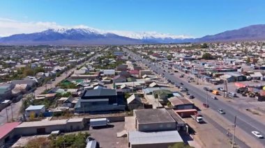 Gökyüzü manzarası, görkemli karlı dağlara karşı inşa edilmiş evleri ve dükkanları olan canlı bir kasaba yakalıyor. Açık gündüz sahnesi uçsuz bucaksız bir faaliyet hissi uyandırıyor..