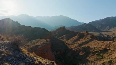 Uçsuz bucaksız dağ manzarası kurak araziyi ve parlak gündüz vakti gökyüzü altında kuru çalıları yakalar. Huzurlu doğal güzellik keşif ve sükuneti davet eder..