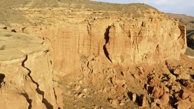 Kırgızistan 'ın kurak kanyonunda büyük kaya oluşumları görkemli bir şekilde yükselir. Drone görünümü.