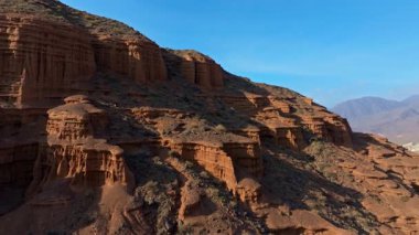 Kırgızistan 'ın kurak çöl arazisindeki çarpıcı kaya oluşumlarını ve jeolojik katmanlarını görüntüler. Huzurlu ve kasvetli manzara korku ve sükuneti çağrıştırıyor..