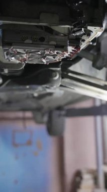 Tamir atölyesinde kaldırılan arabanın altından damlayan hidrolik vana gövdesi.