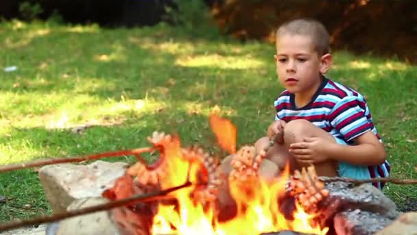 Мальчик печет бекон — стоковое видео