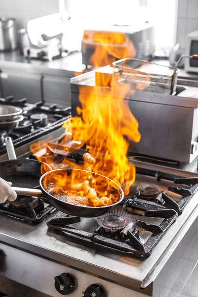 Повар готовит с пламенем — стоковое фото