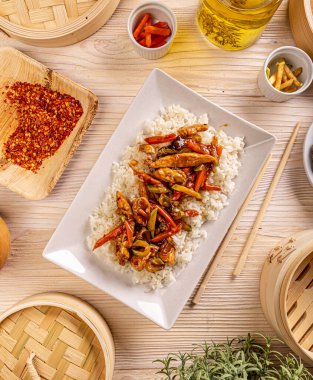 Beyaz tabakta pirinçli tatlı ve ekşi tavuk.