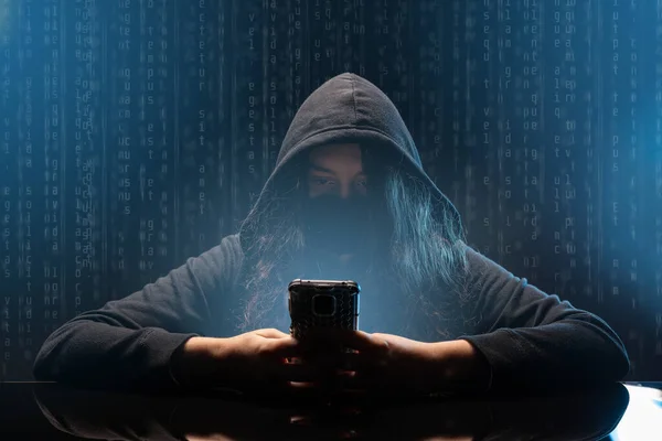 Хакер с мобильным телефоном — стоковое фото
