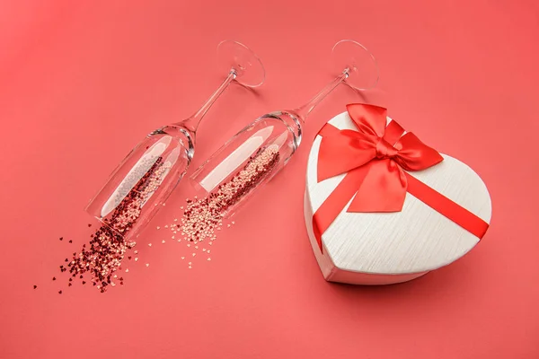 Glas av champagne och hjärtformade presentförpackning Stockfoto