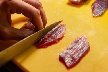 Suşi şefi suşi barında taze ton balığı dilimlemiş..