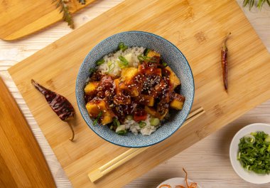 Pirinçle servis edilen baharatlı soslu kızarmış tofunun üst görüntüsü. 