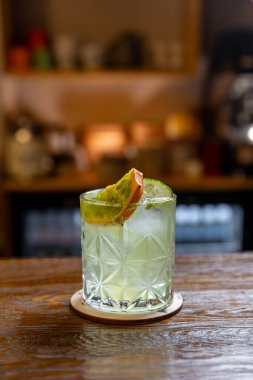 Viski, buz, ahşap bir çubukta kiwano meyvesi dilimi ile süslenmiş eski moda kokteyl.