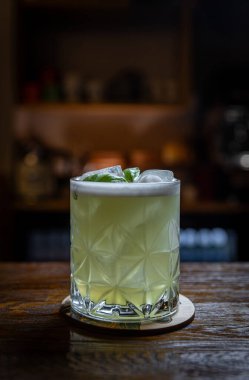 Tahta barın üzerine buz ve köpüklü fesleğen kokteyli.