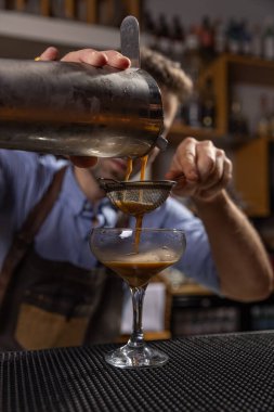 Barmen barda bardağa espresso kokteyli dolduruyor.