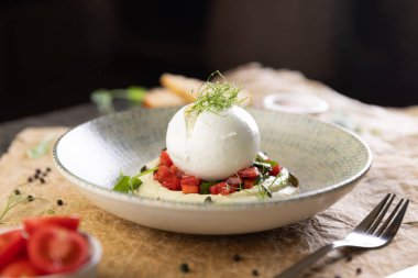 Domatesli ve humuslu İtalyan burrata peyniri. Restoranda yemek.