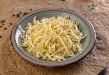 Bir tabağı dolduran dilimlenmiş peynir, pişirmeye hazır.