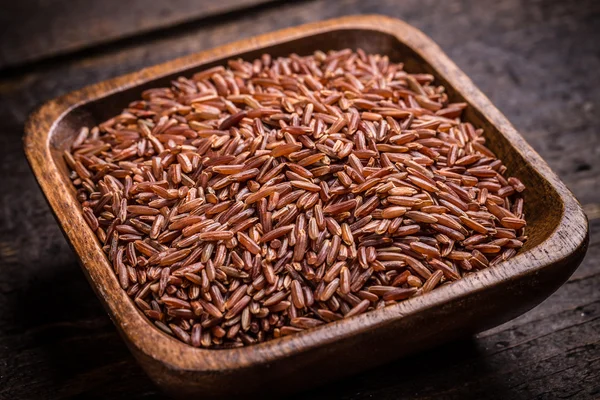 Arroz vermelho em uma tigela de madeira — Fotografia de Stock