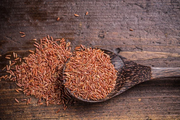 Tahta kaşık kırmızı pirinç — Stok fotoğraf