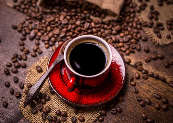 Taza de café y granos de café dispersos —  Fotos de Stock