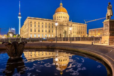 The reconstructed Berlin City Palace and the famous TV Tower at night clipart