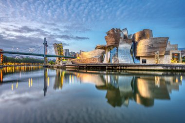 BILBAO, İspanya - 10 Temmuz 2021: Gelecekçi Guggenheim Müzesi güneş doğmadan önce Nervion Nehri 'ne yansıdı