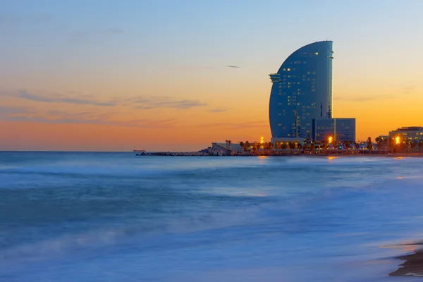 Skyscraper and beach at sunset — Stock Photo, Image