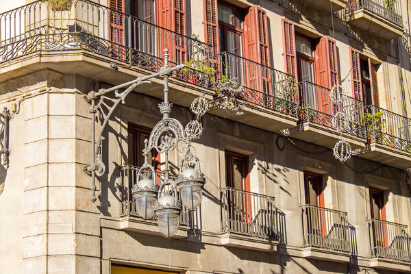 A historic street light in front of a historic house facade seen in Barcelona