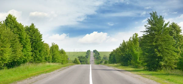 Autoroute parmi les champs verts et le ciel bleu — Photo