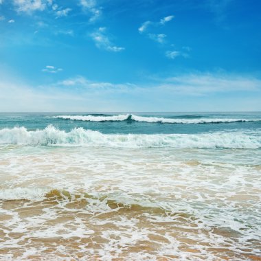 Okyanus dalgaları ve mavi gökyüzü
