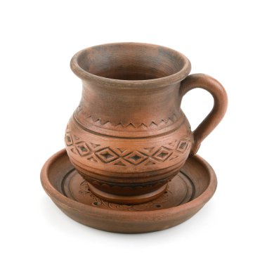 Kabzası ve geometrik desenleri olan taşralı kahverengi bir kupa, basit ve geleneksel bir görünüm için temiz beyaz bir arkaplanda izole edilmiş, uyumlu bir fincan tabağında oturmaktadır..