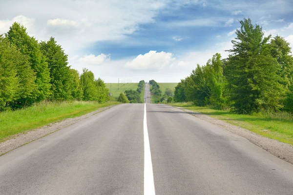 Highway bland gröna fält och blå himmel — Stockfoto