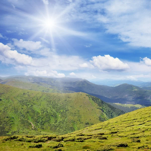 Altas montañas y sol en el cielo azul —  Fotos de Stock