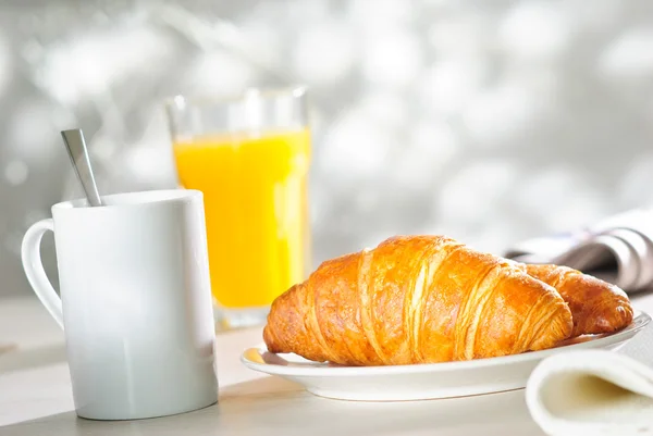 Croissant und Orangensaft lizenzfreie Stockfotos