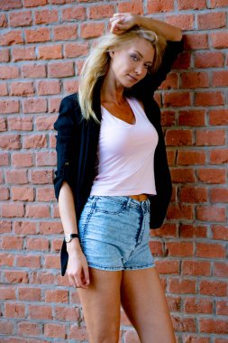 İnce, atletik, uzun, sarışın kız ceketi bankta.